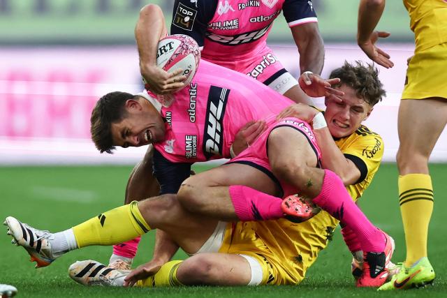 Stade Français Paris' French fly-half Louis (C) Carbonel is tackled by La Rochelle's French fly-half Diego Jurd (R) during the French Top14 rugby union match between Stade Francais and Stade Rochelais at the Jean-Bouin Stadium in Paris on October 31, 2026. (Photo by Anne-Christine POUJOULAT / AFP)
