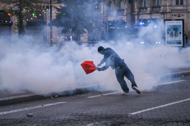 A demonstrator falls as he throws an object during nationwide demonstrations over the rising cost of living and inequality organised by Yellow Vest movement, labour unions and high school and university students, in Bordeaux, southwestern France on October 31, 2026. "Exceptional" security deployment with 70,000 police officers and gendarmes mobilized and an alarmist tone: for Act III of the protests against the high cost of living, right in the middle of Halloween festivities, the authorities fear a repeat of the October 17 nightmare. France has been rocked by widespread anger over the rising cost of living and inequality. (Photo by Christophe ARCHAMBAULT / AFP)