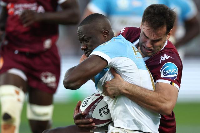 Bayonne's Congolese winger Madosha Tambwe (c) is tackled by Bordeaux' French centre Damian Penaud (R) during the French Top14 rugby union match between Union Bordeaux Bègles (UBB) and Aviron Bayonnais at the Chaban-Delmas stadium in Bordeaux, south-western France, on October 31, 2026. (Photo by ROMAIN PERROCHEAU / AFP)