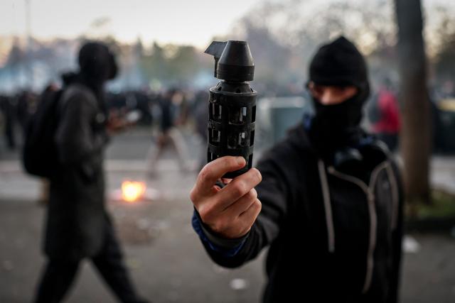 A protester shows a tear gas grenade cartridge during clashes between protesters and law enforcement at the end of a demonstration part of a nationwide day of protests over the rising cost of living and inequality organised by Yellow Vest movement, labour unions and high school and university students organisations, in Paris on October 31, 2026. "Exceptional" security deployment with 70,000 police officers and gendarmes mobilized and an alarmist tone: for Act III of the protests against the high cost of living, right in the middle of Halloween festivities, the authorities fear a repeat of the October 17 nightmare. France has been rocked by widespread anger over the rising cost of living and inequality. (Photo by Sameer AL-DOUMY / AFP)