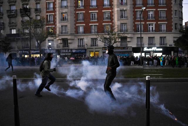 Protesters react in a cloud of tear gas near Porte de Charenton during nationwide demonstrations over the rising cost of living and inequality organised by Yellow Vest movement, labour unions and high school and university students, in Paris on October 31, 2026. "Exceptional" security deployment with 70,000 police officers and gendarmes mobilized and an alarmist tone: for Act III of the protests against the high cost of living, right in the middle of Halloween festivities, the authorities fear a repeat of the October 17 nightmare. France has been rocked by widespread anger over the rising cost of living and inequality. (Photo by JULIEN DE ROSA / AFP)
