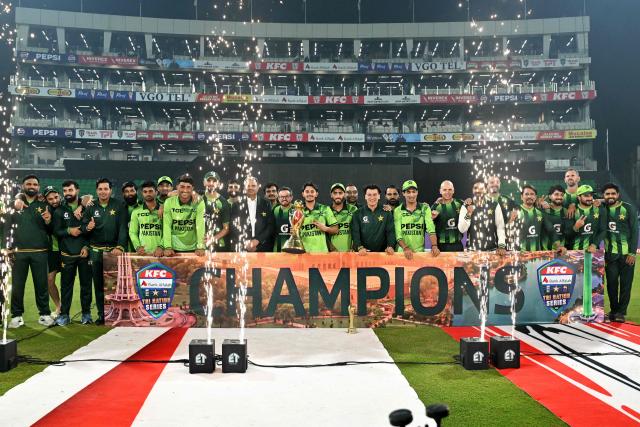 Pakistan's players celebrate with the trophy after their team's win at the end of the one-day international (ODI) tri-series final cricket match between Pakistan and Sri Lanka in the Gaddafi Stadium of Lahore on October 31, 2026. (Photo by ARIF ALI / AFP)
