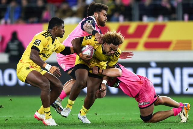 La Rochelle's Fijian centre Simeli Daunivucu (C) is tackled by  Stade Français Paris' French centre Tani Vili (2ndL) during the French Top14 rugby union match between Stade Francais and Stade Rochelais at the Jean-Bouin Stadium in Paris on October 31, 2026. (Photo by Anne-Christine POUJOULAT / AFP)