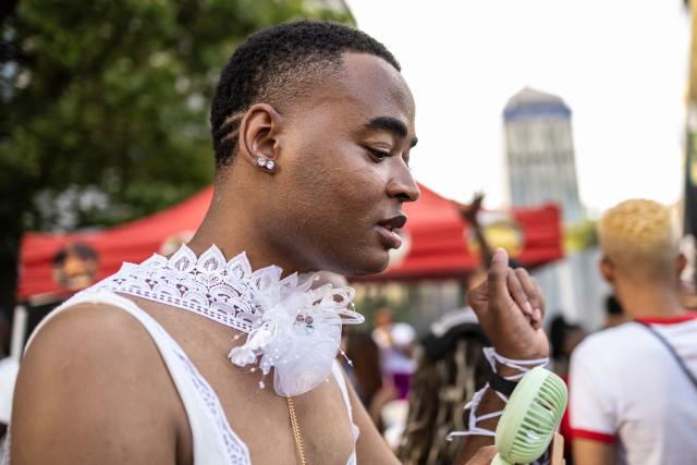An attendee wearing a decorative flower necklace holds a small fan during Johannesburg Pride in Sandton, on October 31, 2026. People filled the streets of Sandton City in Johannesburg for Africa’s oldest Pride event, marking 37 years of protest, courage and celebration. Launched in 1990, before South Africa became a democracy, Johannesburg Pride has grown from an act of defiance under apartheid into a continental movement for equality. (Photo by ILARIA FINIZIO / AFP)