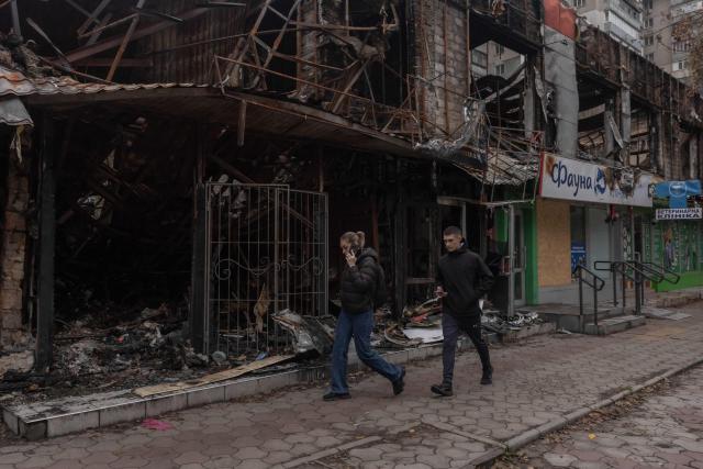 Pedestrians walk past a destroyed cafe and shops which were hit in a previous Russian air attack, during a temporary ceasefire in the southern Kherson region, in the city of Kherson, southern Ukraine, on October 31, 2026, amid the Russian invasion of Ukraine. The respite from a fragile ceasefire in Oleshky, a Russian-occupied town in southern Ukraine ravaged by food and medicine shortages, to pave the way for evacuations and humanitarian aid deliveries and due to end on November 1 evening, has also given residents in the major southern Ukrainian city of Kherson relief from daily drone attacks. The truce has held despite unabated attacks elsewhere in Ukraine. (Photo by Roman PILIPEY / AFP)