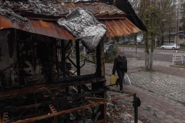 A pedestrian man with bags walks past a destroyed building which was hit in a previous Russian air attack during a temporary ceasefire in the southern Kherson region, in the city of Kherson, southern Ukraine, on October 31, 2026, amid the Russian invasion of Ukraine. The respite from a fragile ceasefire in Oleshky, a Russian-occupied town in southern Ukraine ravaged by food and medicine shortages, to pave the way for evacuations and humanitarian aid deliveries and due to end on November 1 evening, has also given residents in the major southern Ukrainian city of Kherson relief from daily drone attacks. The truce has held despite unabated attacks elsewhere in Ukraine. (Photo by Roman PILIPEY / AFP)