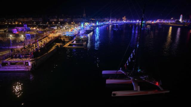 This aerial photograph shows Sodebo Ocean Fifty class leaving at night the harbour of Saint-Malo, western France, on October 31, 2026, ahead of the start of the 13th Route du Rhum - Destination Guadeloupe solo sailing race from Saint-Malo, western France to Pointe-a-Pitre in the French overseas island of Guadeloupe. (Photo by LOU BENOIST / AFP)