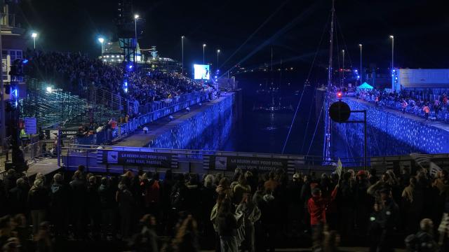 This aerial photograph shows Ocean Fifty class leaving at night the harbour of Saint-Malo, western France, on October 31, 2026, ahead of the start of the 13th Route du Rhum - Destination Guadeloupe solo sailing race from Saint-Malo, western France to Pointe-a-Pitre in the French overseas island of Guadeloupe. (Photo by LOU BENOIST / AFP)