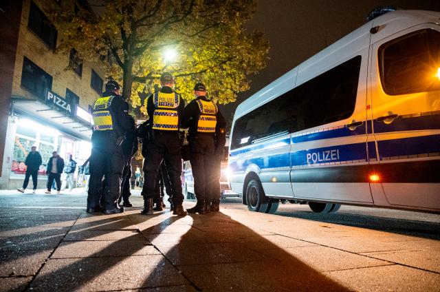 31 October 2024, Hamburg: Police officers stand ready in the Harburg district in the evening. After last year's riots, Halloween in Hamburg remained quiet for the time being. Photo: Daniel Bockwoldt/dpa