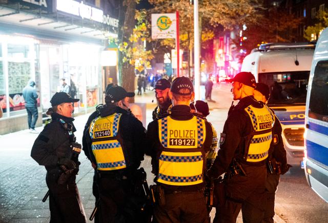 31 October 2024, Hamburg: Police officers stand ready in the Harburg district in the evening. After last year's riots, Halloween in Hamburg remained quiet for the time being. Photo: Daniel Bockwoldt/dpa