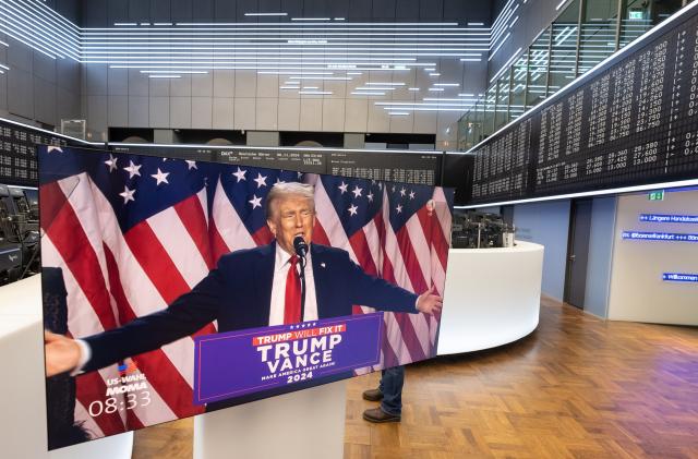 06 November 2024, Berlin, Frankfurt/Main: A speech by US presidential candidate Donald Trump is broadcasted live on a monitor in the trading hall of Deutsche Boerse in Frankfurt. Meanwhile, Trump has declared himself the winner of the election. Photo: Boris Roessler/dpa