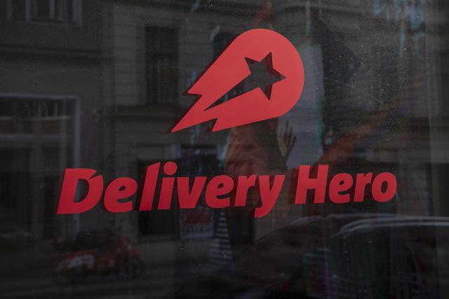 FILED - 11 February 2022, Berlin: The logo and lettering of the food delivery service Delivery Hero can be seen in a window at the company's headquarters. Photo: Paul Zinken/ZB/dpa