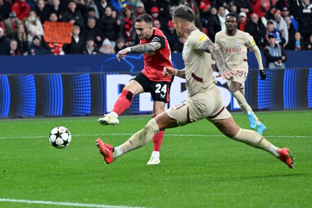 26 November 2024, North Rhine-Westphalia, Leverkusen: Leverkusen's Aleix Garcia (L) shoots at goal during the UEFA Champions League soccer match between Bayer Leverkusen and RB Salzburg at BayArena. Photo: Federico Gambarini/dpa