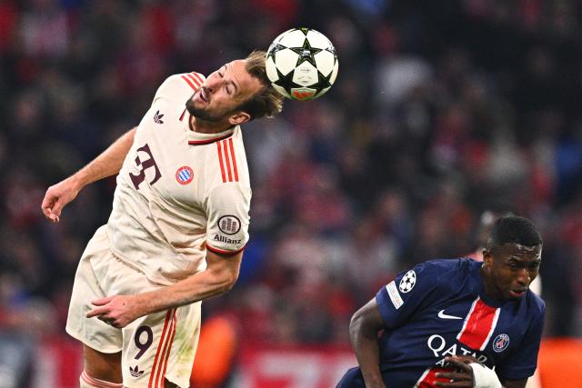 26 November 2024, Bavaria, Munich: Munich's Harry Kane (L) and Paris Saint-Germain's Willian Pacho battle for the ball during the UEFA Champions League soccer match between FC Bayern Munich and Paris Saint-Germain at the Allianz Arena. Photo: Tom Weller/dpa