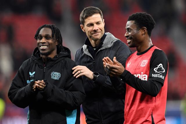 26 November 2024, North Rhine-Westphalia, Leverkusen: Leverkusen coach Xabi Alonso (C) celebrates with Jeremie Frimpong (L) and Nathan Tella after during the UEFA Champions League soccer match between Bayer Leverkusen and RB Salzburg at BayArena. Photo: Federico Gambarini/dpa