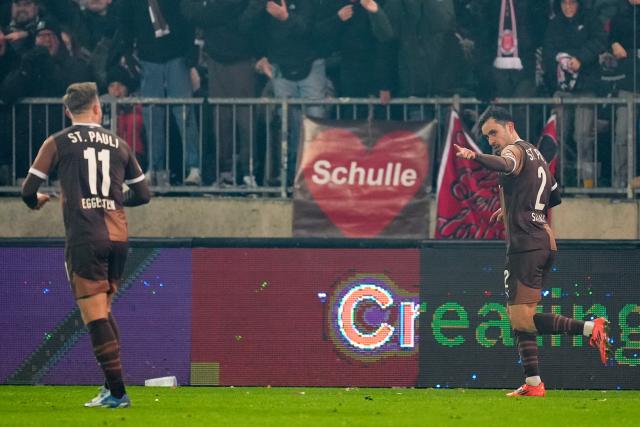 29 November 2024, Hamburg: St. Pauli's Manolis Saliakas (R) celebrates scoring his side's first goal during the German Bundesliga soccer match between FC St. Pauli and Holstein Kiel at the Millerntor Stadium. Photo: Marcus Brandt/dpa - WICHTIGER HINWEIS: Gemäß den Vorgaben der DFL Deutsche Fußball Liga bzw. des DFB Deutscher Fußball-Bund ist es untersagt, in dem Stadion und/oder vom Spiel angefertigte Fotoaufnahmen in Form von Sequenzbildern und/oder videoähnlichen Fotostrecken zu verwerten bzw. verwerten zu lassen.