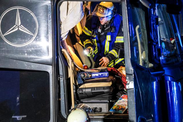 30 November 2024, North Rhine-Westphalia, Hagen: A firefighter examines the driver's cab of a truck at the scene of an accident on the Autobahn 1 near Hagen. Several people were seriously injured during the chaotic journey of a truck across several highways in North Rhine-Westphalia, according to the police. Photo: Alex Talash/dpa