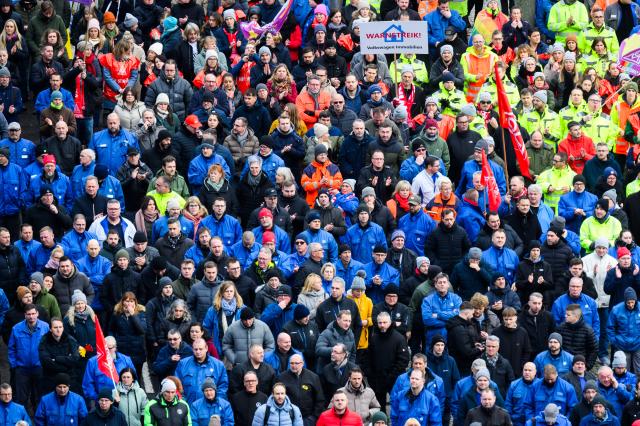 02 December 2024, Lower Saxony, Wolfsburg: Volkswagen employees stand at a strike rally on the grounds of the VW main plant in Wolfsburg. IG Metall calls for warning strikes at several German Volkswagen sites over wage cuts, lay-offs. Photo: Julian Stratenschulte/dpa Pool/dpa