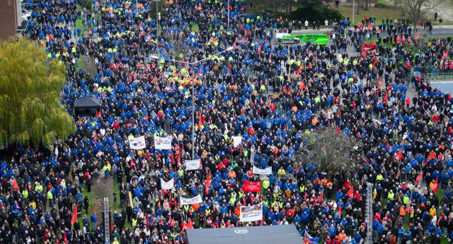 02 December 2024, Lower Saxony, Wolfsburg: Volkswagen employees stand at a strike rally on the grounds of the VW main plant in Wolfsburg. IG Metall calls for warning strikes at several German Volkswagen sites over wage cuts, lay-offs. Photo: Julian Stratenschulte/dpa Pool/dpa