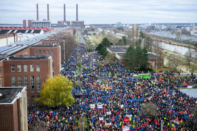 02 December 2024, Lower Saxony, Wolfsburg: Volkswagen employees stand at a strike rally on the grounds of the VW main plant in Wolfsburg. IG Metall calls for warning strikes at several German Volkswagen sites over wage cuts, lay-offs. Photo: Julian Stratenschulte/dpa Pool/dpa