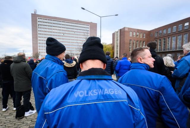 02 December 2024, Lower Saxony, Wolfsburg: Volkswagen employees stand at a strike rally on the grounds of the VW main plant in Wolfsburg.  IG Metall is calling for warning strikes at several Volkswagen sites in Germany over wage cuts, lay-offs. Photo: Julian Stratenschulte/dpa Pool/dpa