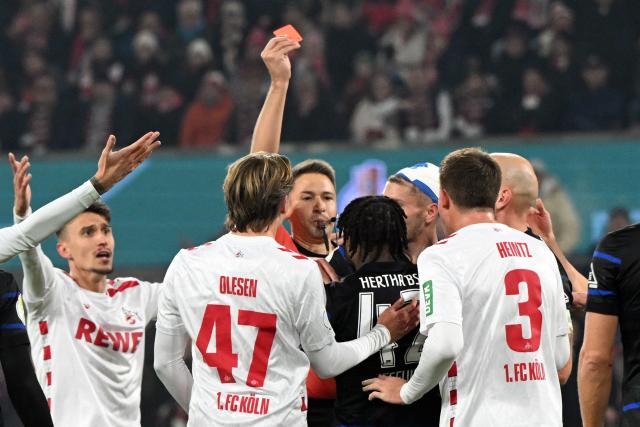 04 December 2024, North Rhine-Westphalia, Cologne: Referee Tobias Reichel shows Berlin's Deyovaisio Zeefuik (C) the red card during the German DFB Cup round of 16 soccer match between 1. FC Cologne and Hertha Berlin at the RheinEnergieSTADION. Photo: Federico Gambarini/dpa - WICHTIGER HINWEIS: Gemäß den Vorgaben der DFL Deutsche Fußball Liga bzw. des DFB Deutscher Fußball-Bund ist es untersagt, in dem Stadion und/oder vom Spiel angefertigte Fotoaufnahmen in Form von Sequenzbildern und/oder videoähnlichen Fotostrecken zu verwerten bzw. verwerten zu lassen.