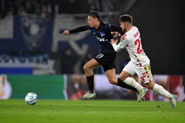 04 December 2024, North Rhine-Westphalia, Cologne: Cologne's Jan Thielmann (R) and Berlin's Derry Scherhant battle for the ball during the German DFB Cup round of 16 soccer match between 1. FC Cologne and Hertha Berlin at the RheinEnergieSTADION. Photo: Federico Gambarini/dpa - WICHTIGER HINWEIS: Gemäß den Vorgaben der DFL Deutsche Fußball Liga bzw. des DFB Deutscher Fußball-Bund ist es untersagt, in dem Stadion und/oder vom Spiel angefertigte Fotoaufnahmen in Form von Sequenzbildern und/oder videoähnlichen Fotostrecken zu verwerten bzw. verwerten zu lassen.