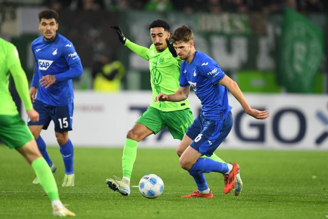 04 December 2024, Lower Saxony, Wolfsburg: Hoffenheim's Anton Stach (R) and Wolfsburg's Tiago Tomas battle for the ball during the German DFB Cup round of 16 soccer match between VfL Wolfsburg and TSG 1899 Hoffenheim at the Volkswagen Arena Photo: Swen Pförtner/dpa - WICHTIGER HINWEIS: Gemäß den Vorgaben der DFL Deutsche Fußball Liga bzw. des DFB Deutscher Fußball-Bund ist es untersagt, in dem Stadion und/oder vom Spiel angefertigte Fotoaufnahmen in Form von Sequenzbildern und/oder videoähnlichen Fotostrecken zu verwerten bzw. verwerten zu lassen.