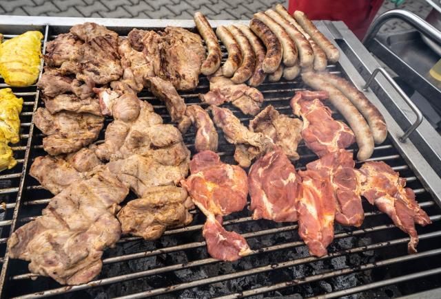 FILED - 08 July 2022, Hesse, Giessen: Numerous pieces of meat and sausages placed on a large charcoal grill. A YouGov survey commissioned by dpa and published on 19 December showed 39% of Germans would like learn about animal husbandry when visiting a restaurant. Photo: Frank Rumpenhorst/dpa