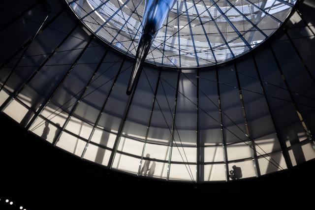 20 December 2024, Berlin: Shadows of individuals are silhouetted against the blinds on the parliamentary group level inside the dome of the Reichstag building. The agenda for the 208th session includes votes on funding the Deutschlandticket and amending the Energy Industry Act, alongside debates on introducing animal husbandry logos in restaurants and improving working conditions in the parcel delivery sector. Photo: Christoph Soeder/dpa