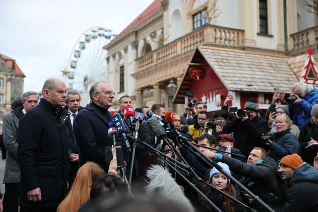 21 December 2024, Saxony-Anhalt, Magdeburg: Germany's Chancellor Olaf Scholz (L) and Reiner Haseloff, Minister President of Saxony-Anhalt, visit and address the scene of the fatal attack at Magdeburg's Christmas market. The previous evening, a driver plowed into a crowd at the market, leaving several dead and injured. Photo: Jan Woitas/dpa