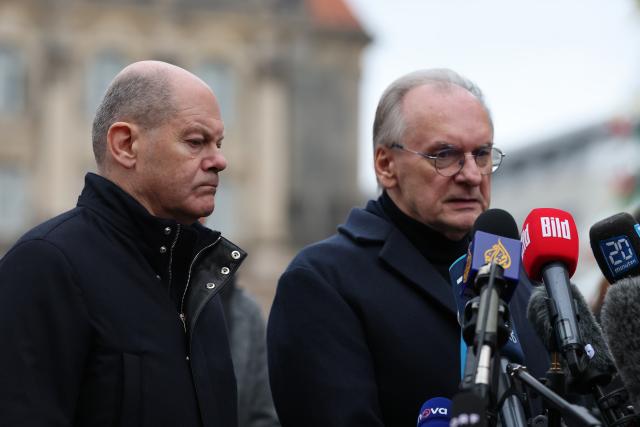 21 December 2024, Saxony-Anhalt, Magdeburg: German Chancellor Olaf Scholz (L) and Reiner Haseloff, Minister President of Saxony-Anhalt, visit and speak at the scene of the fatal attack at Magdeburg's Christmas market. The previous evening, a car driver struck a group of people at the market, resulting in multiple fatalities and injuries. Photo: Jan Woitas/dpa