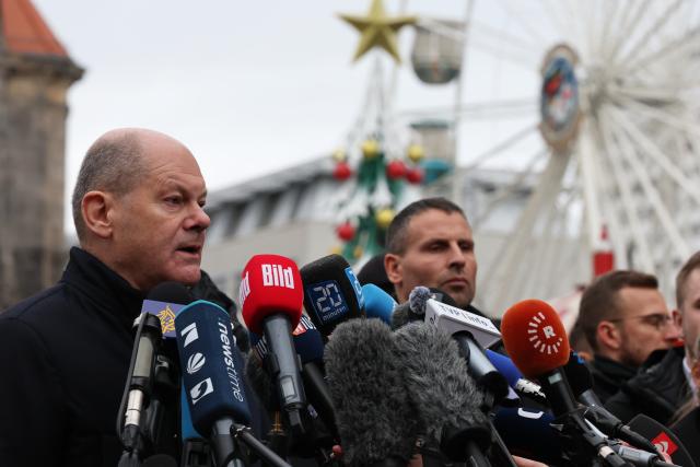 21 December 2024, Saxony-Anhalt, Magdeburg: Germany's Chancellor Olaf Scholz (L) delivers a statement alongside Reiner Haseloff, Minister President of Saxony-Anhalt, following their visit to the scene of the fatal attack at Magdeburg's Christmas market. The previous evening, a car driver struck a group of people at the market, causing multiple fatalities and injuries. Photo: Jan Woitas/dpa