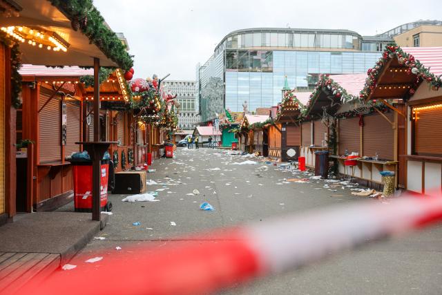 21 December 2024, Saxony-Anhalt, Magdeburg: Christmas market stalls stand behind a barrier at Magdeburg's Christmas market, where the previous evening, a driver rammed into a group of people. Several people were killed and injured in the attack. Photo: Jan Woitas/dpa