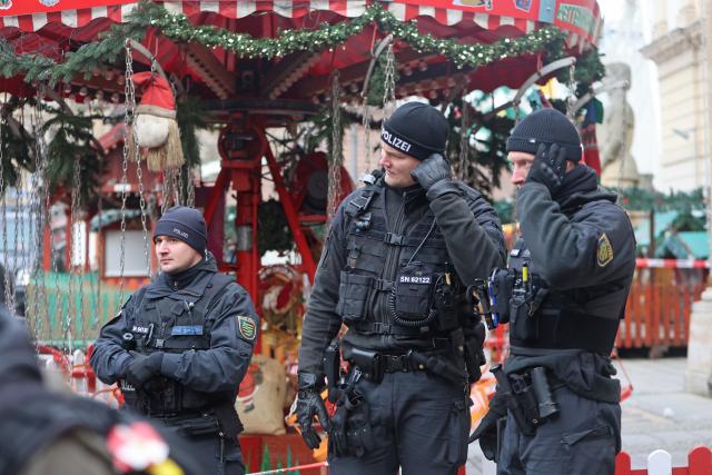 21 December 2024, Saxony-Anhalt, Magdeburg: Police officers stand in front of a carousel at Magdeburg's Christmas market, where the previous evening, a driver rammed into a group of people. Several people were killed and injured in the attack. Photo: Matthias Bein/dpa