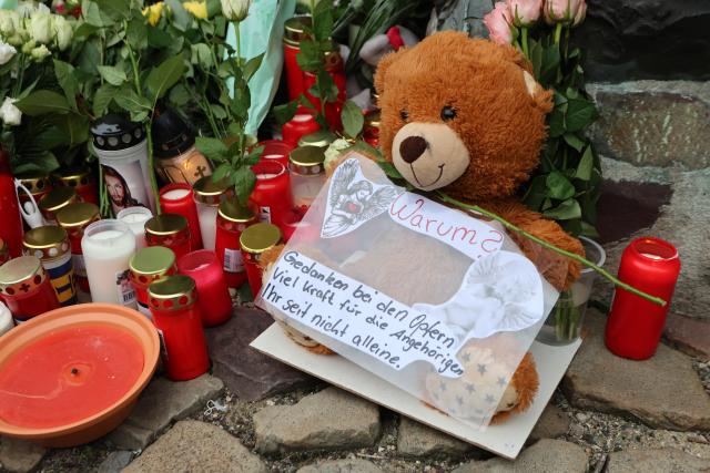 21 December 2024, Saxony-Anhalt, Magdeburg: A plush teddy bear lies between flowers and candles at the official place of mourning in front of St. John's Church in Magdeburg. The previous evening, a driver rammed into a group of people at Magdeburg's Christmas market. Several people were killed and injured in the attack. Photo: Matthias Bein/dpa