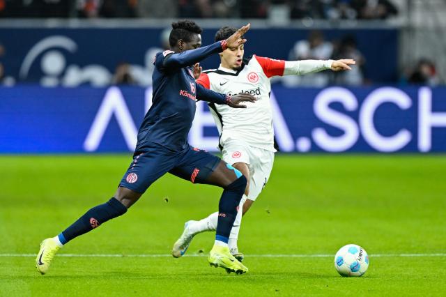 21 December 2024, Hesse, Frankfurt_Main: Mainz's Danny da Costa (L) and Frankfurt's Fares Chaibi battle for the ball, during the German Bundesliga soccer match between Eintracht Frankfurt and FSV Mainz 05 at the Deutsche Bank Park. Photo: Uwe Anspach/dpa - IMPORTANT NOTE: In accordance with the regulations of the DFL German Football League and the DFB German Football Association, it is prohibited to utilize or have utilized photographs taken in the stadium and/or of the match in the form of sequential images and/or video-like photo series.