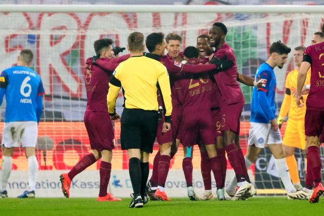 21 December 2024, Schleswig-Holstein, Kiel: Augsburg's players celebrate their side's first goal, scored by Alexis Claude-Maurice during the German Bundesliga soccer match between Holstein Kiel and FC Augsburg at Holstein Stadium. Photo: Frank Molter/dpa - IMPORTANT NOTICE: DFL and DFB regulations prohibit any use of photographs as image sequences and/or quasi-video.