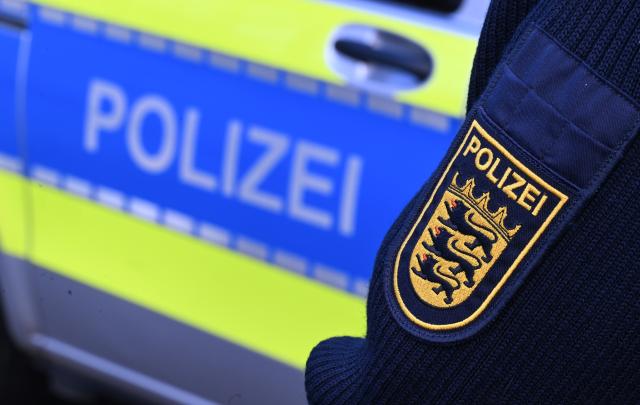 FILED - 03 December 2024, Baden-Württemberg, Stuttgart: A German policeman stands next to a police car in Stuttgart. Photo: Bernd Weißbrod/dpa