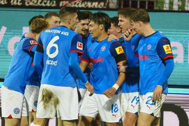 21 December 2024, Schleswig-Holstein, Kiel: Kiel's Shuto Machino (C) celebrates scoring his side's fourth goal with his teammates during the German Bundesliga soccer match between Holstein Kiel and FC Augsburg at Holstein Stadium. Photo: Frank Molter/dpa - IMPORTANT NOTICE: DFL and DFB regulations prohibit any use of photographs as image sequences and/or quasi-video.