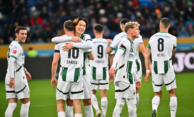 21 December 2024, Baden-Württemberg, Sinsheim: Moenchengladbach players celebrate their side's first goal by Philipp Sander (2nd L) during the German Bundesliga soccer match between TSG 1899 Hoffenheim and Bor. Moenchengladbach at PreZero Arena. Photo: Jan-Philipp Strobel/dpa - IMPORTANT NOTE: In accordance with the regulations of the DFL German Football League and the DFB German Football Association, it is prohibited to utilize or have utilized photographs taken in the stadium and/or of the match in the form of sequential images and/or video-like photo series.