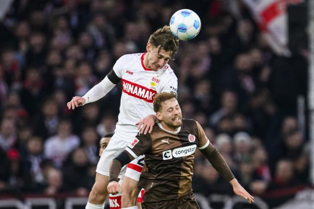 21 December 2024, Baden-Württemberg, Stuttgart: Stuttgart's Anthony Rouault (L) in action against St. Pauli's Carlo Boukhalfa, during the German Bundesliga soccer match between VfB Stuttgart and FC St. Pauli at MHPArena. Photo: Tom Weller/dpa - IMPORTANT NOTE: In accordance with the regulations of the DFL German Football League and the DFB German Football Association, it is prohibited to utilize or have utilized photographs taken in the stadium and/or of the match in the form of sequential images and/or video-like photo series.