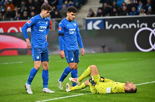 21 December 2024, Baden-Württemberg, Sinsheim: Hoffenheim's Oliver Baumann (R) lies on the ground, during the German Bundesliga soccer match between TSG 1899 Hoffenheim and Bor. Moenchengladbach at PreZero Arena. Photo: Jan-Philipp Strobel/dpa - IMPORTANT NOTE: In accordance with the regulations of the DFL German Football League and the DFB German Football Association, it is prohibited to utilize or have utilized photographs taken in the stadium and/or of the match in the form of sequential images and/or video-like photo series.