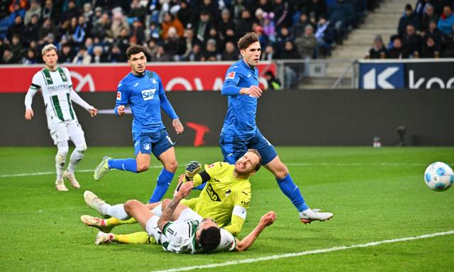 21 December 2024, Baden-Württemberg, Stuttgart: Hoffenheim goalkeeper Oliver Baumann (C) and Moenchengladbach's Tim Kleindienst battle for the ball, during the German Bundesliga soccer match between VfB Stuttgart and FC St. Pauli at MHPArena. Photo: Jan-Philipp Strobel/dpa - IMPORTANT NOTE: In accordance with the regulations of the DFL German Football League and the DFB German Football Association, it is prohibited to utilize or have utilized photographs taken in the stadium and/or of the match in the form of sequential images and/or video-like photo series.