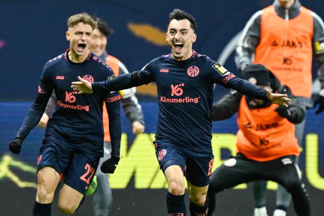 21 December 2024, Hesse, Frankfurt_Main: Mainz's Paul Nebel (C) celebrates scoring his side's third goal, during the German Bundesliga soccer match between Eintracht Frankfurt and FSV Mainz 05 at the Deutsche Bank Park. Photo: Uwe Anspach/dpa - IMPORTANT NOTE: In accordance with the regulations of the DFL German Football League and the DFB German Football Association, it is prohibited to utilize or have utilized photographs taken in the stadium and/or of the match in the form of sequential images and/or video-like photo series.