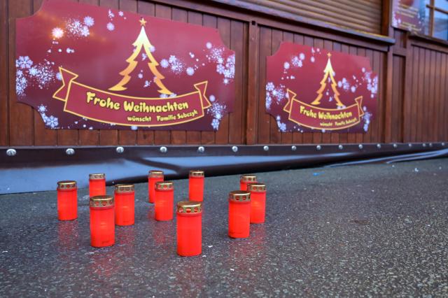 26 December 2024, Saxony-Anhalt, Magdeburg: Candles are placed on the ground at a stand at the Christmas market as a tribute to the victims of Magdeburg Christmas market. After a car drove into a crowd of people at the Christmas market on 20.12.2024, the grief and consternation continues. Photo: Heiko Rebsch/dpa