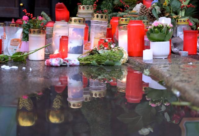 26 December 2024, Saxony-Anhalt, Magdeburg: Candles are reflected in a puddle at the Christmas market as a tribute to the victims of Magdeburg Christmas market. After a car drove into a crowd of people at the Christmas market on 20.12.2024, the grief and consternation continues. Photo: Heiko Rebsch/dpa