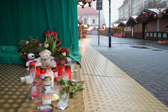 26 December 2024, Saxony-Anhalt, Magdeburg: Candles, cuddly toys and flowers are placed on the ground at a stand at the Christmas market as a tribute to the victims of Magdeburg Christmas market. After a car drove into a crowd of people at the Christmas market on 20.12.2024, the grief and consternation continues. Photo: Heiko Rebsch/dpa