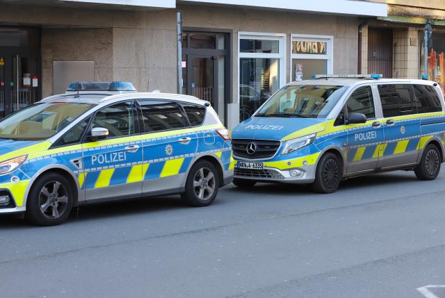 26 December 2024, North Rhine-Westphalia, Hagen: Police vehicles are parked in front of a house in Hagen. A man was arrested in Hagen after making suspicious comments on a social network. According to the German Press Agency, the man had bragged about threatening attacks on a messenger service. Photo: Sscha Thelen/dpa