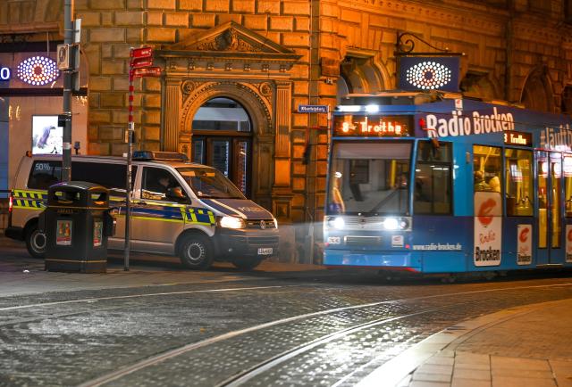 26 December 2024, Saxony-Anhalt, Halle (Saale): A police vehicle, parked in front of the Halle Winter Market "Winterzauber" as an access barrier, allows a streetcar to pass. The Halle Winter Market has been organized by the City-Gemeinschaft Halle e.V. since 2009. Photo: Heiko Rebsch/dpa